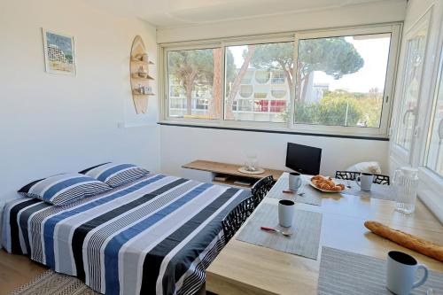 a bedroom with a bed and a desk with a computer at Studio tout équipé vue sur Port in La Grande-Motte