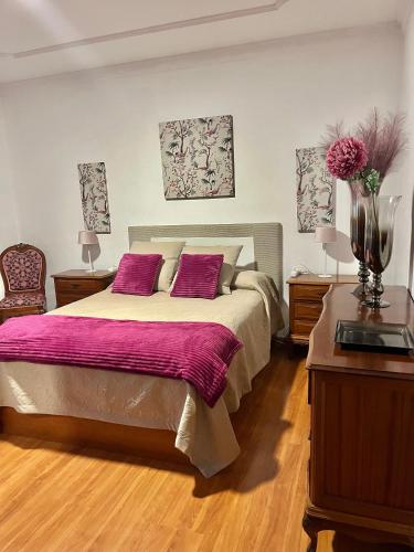 a bedroom with a large bed with two purple pillows at Teror Centro 2 in Teror