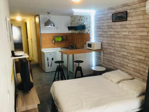 Cet appartement comprend une chambre avec un lit et une cuisine avec un comptoir. dans l'établissement La Barbacane, à Lapalme