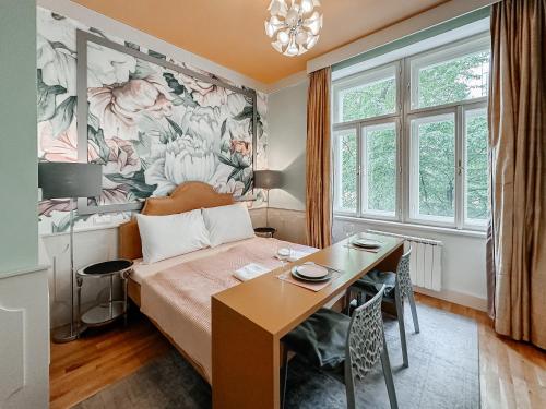 Un dormitorio con una cama, un escritorio y una mesa. en ELSO Muzeum apartments, en Praga