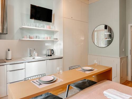 eine Küche und ein Esszimmer mit einem Tisch und einem Spiegel in der Unterkunft ELSO Muzeum apartments in Prag