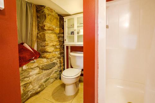 a bathroom with a toilet and a stone wall at Stone Manor Boutique Inn in Britain