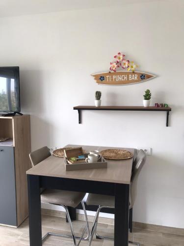 une table à manger avec deux chaises, une table et une étagère dans l'établissement Studio direct plage, au Lavandou