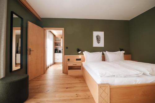 sypialnia z dużym białym łóżkiem i zielonymi ścianami w obiekcie Garni Appartements Arnika w mieście Solda