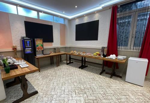 einen Konferenzraum mit zwei Tischen und einem TV in der Unterkunft Hôtel Elaïa in Corps