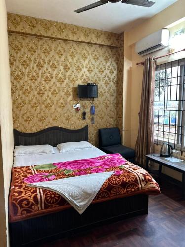 een slaapkamer met een bed met een roze deken erop bij Hotel Opera in Bharatpur