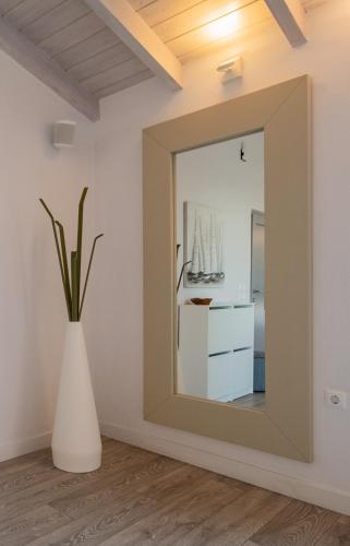 a mirror in a room with a white vase at Villa Krokos in Corfu