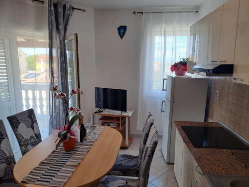 a kitchen with a table with chairs and a dining room at Apartmani Mila-Casa Bianca in Medulin