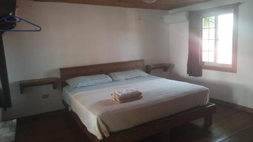 ein Schlafzimmer mit einem Bett mit zwei Handtüchern darauf in der Unterkunft Panama Dive School in Bocas del Toro