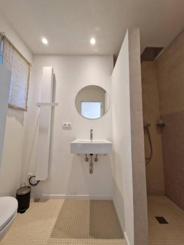 uma casa de banho com um lavatório e um WC em Tiny house em Antuérpia