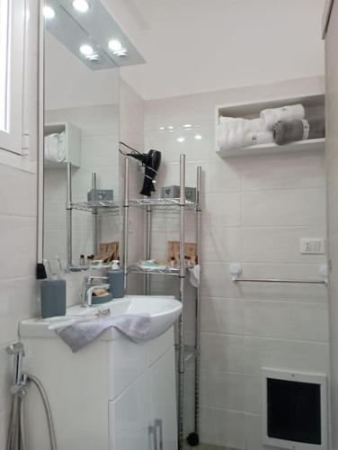 a white bathroom with a sink and a shower at Maria's guesthouse in Letojanni