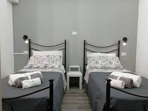 a bedroom with two beds and a chair at Maria's guesthouse in Letojanni
