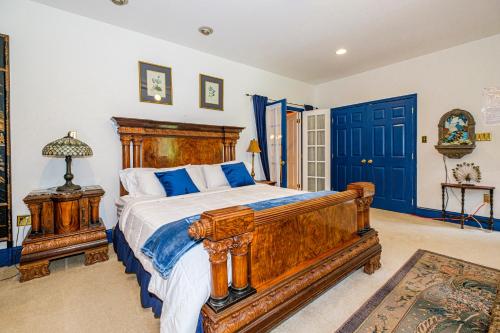 a bedroom with a large wooden bed with blue pillows at Stone Manor Boutique Inn in Britain