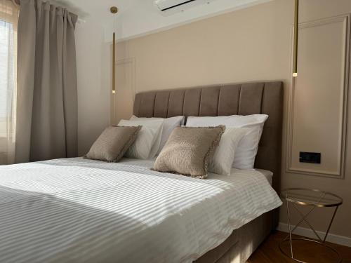 een slaapkamer met een groot bed met witte lakens en kussens bij Magnolia deluxe Apartment in Zagreb