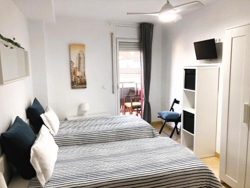 1 dormitorio con 1 cama y TV en CENTRICO y ACOGEDOR APARTAMENTO, en Girona