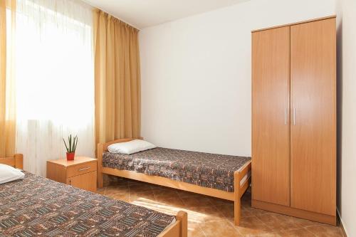 a hotel room with two beds and a cabinet at Апартаменты в Каменари in Kamenari