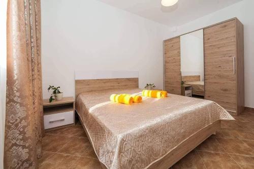a bedroom with a bed with yellow pillows on it at Апартаменты в Каменари in Kamenari