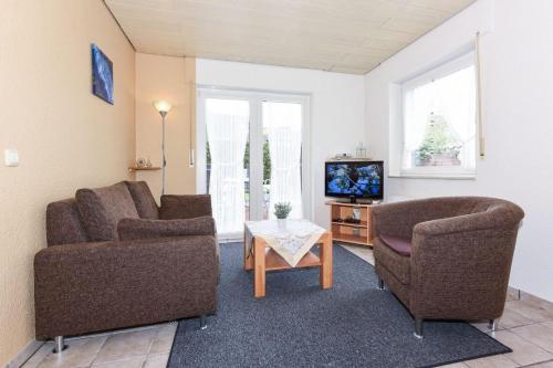 un soggiorno con 2 sedie e una TV di Seekieker - Nordseewelle a Esens