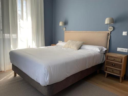 a bedroom with a large white bed and a window at Santa Eulalia in Lugo