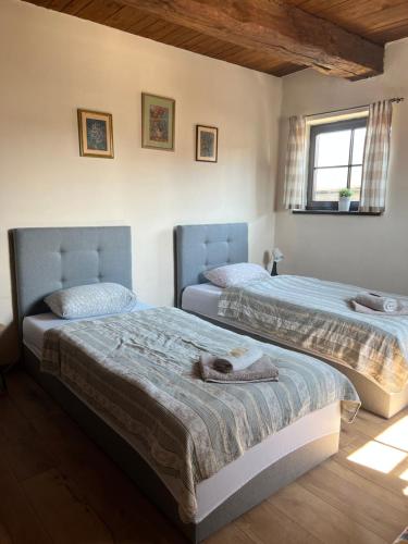 a bedroom with two beds and a window at Stary Spichrz Kawiarnia & Noclegi in Chełmno