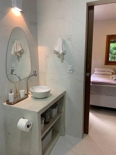 un bagno con lavandino, specchio e letto di Chalé verde - Moreré a Moreré