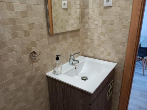 a bathroom with a sink and a mirror at Casa Bateira in Figueira da Foz