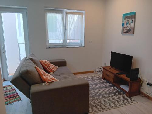 a living room with a couch and a tv at Casa Bateira in Figueira da Foz