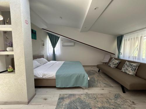 a bedroom with a bed and a couch at La Casa Verde in Buşteni