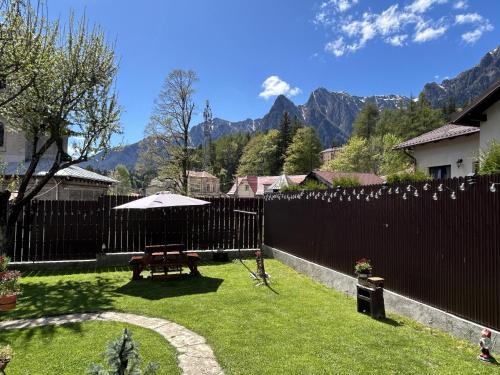 a backyard with a wooden fence and a picnic table at La Casa Verde in Buşteni