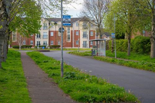 a street sign in the grass next to a road at Stylish & spacious 3 bedroom entire house in Lisburn with parking in Lisburn