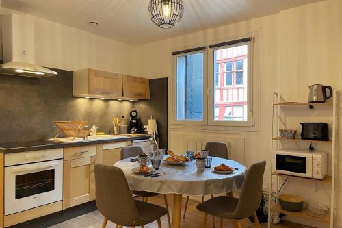 une cuisine avec une table et des chaises dans une cuisine dans l'établissement L'Escale de Saint Maclou-Rouen centre Historique, à Rouen