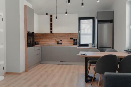 une cuisine avec des armoires blanches et une table en bois dans l'établissement Hugo, à Varna