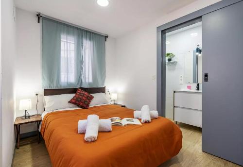 een slaapkamer met een groot oranje bed met handdoeken erop bij Apartamento Sierra Nevada Viva in Otura