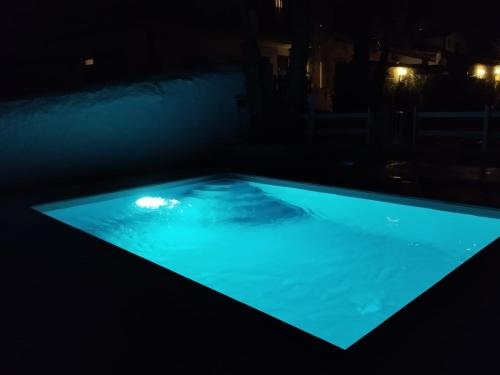 a swimming pool lit up at night at Agriturismoeloropizzuta in Noto Marina