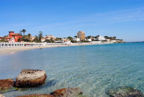 a beach with a rock in the water at APPARTAMENTO con TERRAZZA SUL MARE in Santa Marinella