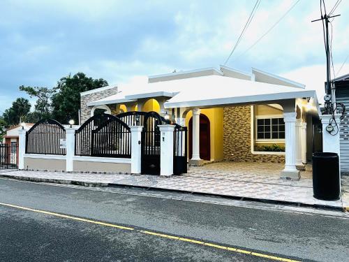 een huis met een hek aan de straatkant bij Vacation Family Home 5 min from STI Airport WiFi-AC-Netflix 