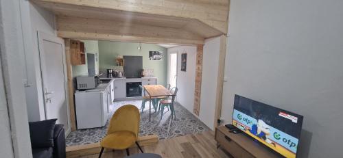 sala de estar con TV y cocina en Le Tillois, en Tilly-sur-Seulles