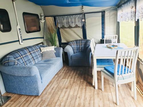ein Wohnzimmer mit einem Sofa und einem Tisch in der Unterkunft Luxoriöser Wohnwagen 400 Meter vom Meer in Grömitz. in Lenste