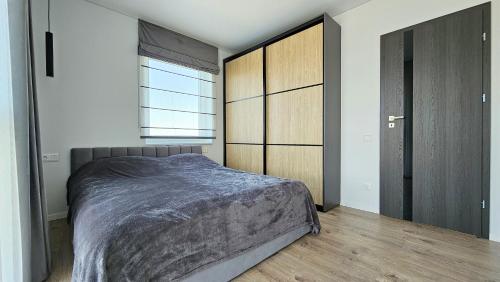 a bedroom with a bed and cabinets and a window at Palanga - Šventosios pajūrio namai in Palanga
