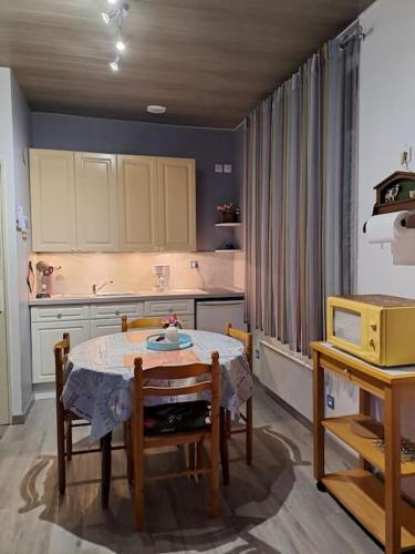 une cuisine avec une table et des chaises et une table et une cuisine dans l'établissement Appartement lumineux 1er étage, à Boulogne-sur-Mer