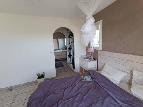 une chambre avec un lit avec une couette violette dans l'établissement Villa Reillanne Luberon, à Reillanne