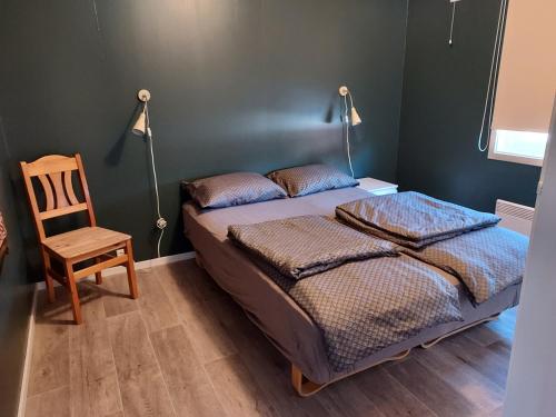 a bedroom with two beds and a wooden chair at Sentrumsnær overnatting in Alta