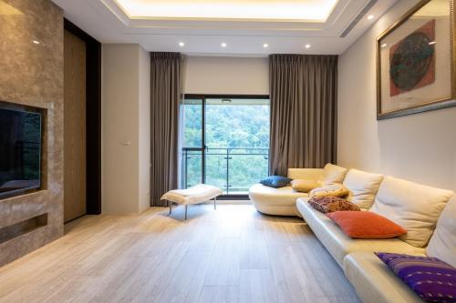 a living room with a couch and a large window at Siang Tsao Yu Chong in Sanyi