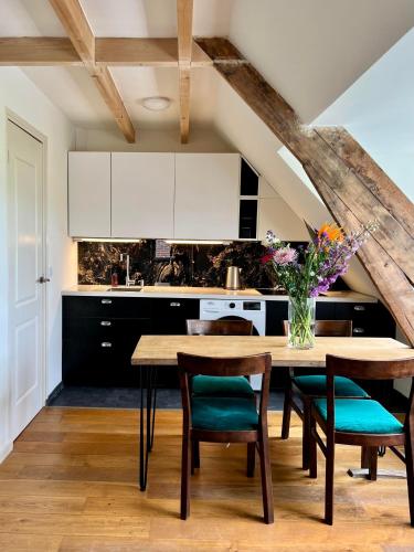 a kitchen with a wooden table with chairs and a counter at The Grutto, private apartment 25 min from city center in Amsterdam