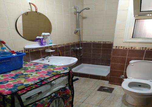 a bathroom with a toilet and a sink and a mirror at Blumar Sidi Abdel Rahman 2 bedrooms Chalet North Coast in El Alamein