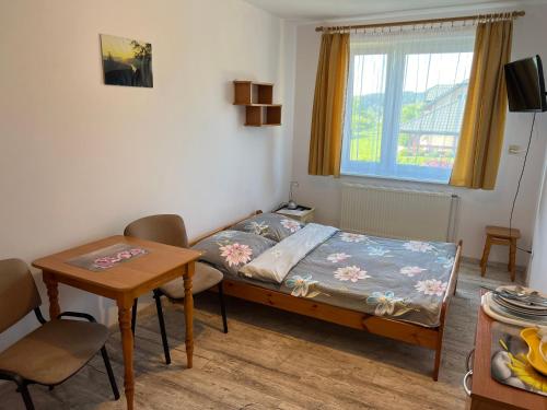 a small bedroom with a bed and a table at Nad Bieszczadzkim Morzem in Polańczyk
