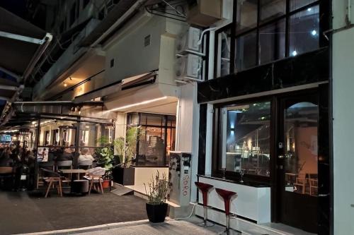 um edifício com janelas e pessoas sentadas à mesa em Karditsa's Loft House em Karditsa