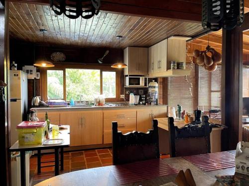 a kitchen with wooden cabinets and a table with chairs at María Ce - Cabaña familiar en el K25 vía al mar in Papagalleros