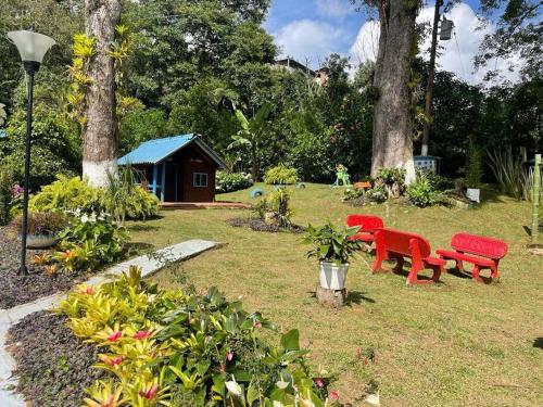 a park with two red benches and a smallshed at María Ce - Cabaña familiar en el K25 vía al mar in Papagalleros