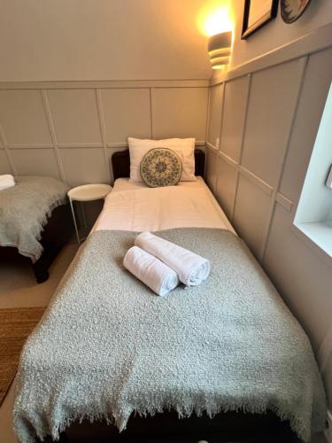 a small room with two beds with towels on the bed at NEON Apartman Csopak Balaton, large botanical garden, bicycles, pet&family friendly, outside kitchen, in Csopak